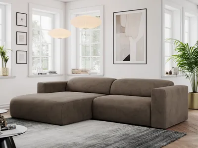 A modern living room with a large sectional sofa, artwork, and plants.
