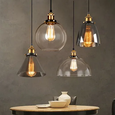 Four pendant lights hanging above a table with decorative items.
