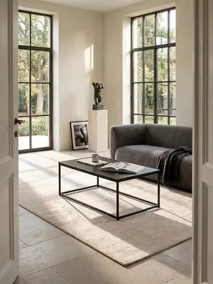 Rechteckiger Couchtisch mit dunkler Marmor-Optik und filigranem Metallgestell im puristischen Wohnzimmer, elegant inszeniert auf geschliffenem Kalksteinboden vor einer hellen Fensterfront_#sku_SAFWL6.607#