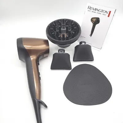 A hairdryer and its accessories are laid out on a white background, along with a product manual.