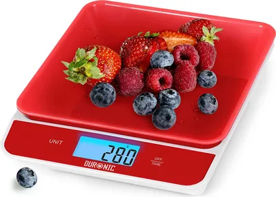 A red kitchen scale with berries on it, displaying a weight of 280.