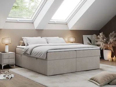 A bedroom with a bed, nightstand, and decorative items, illuminated by natural light from skylights.