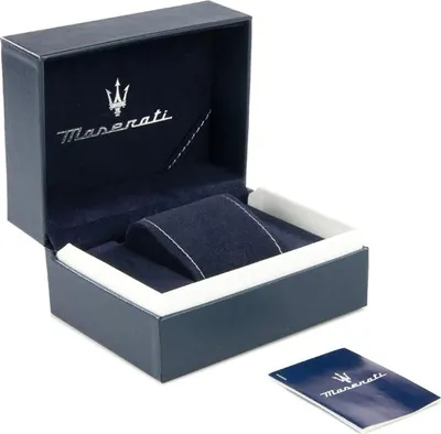 An open dark blue Maserati watch box with a white insert and a small booklet on the side.