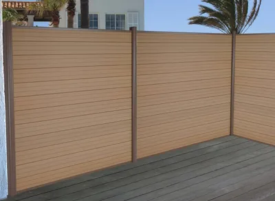 A modern wooden fence with aluminum posts on a wooden deck, with a house and palm trees in the background.