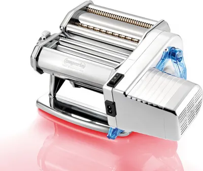 A chrome-plated electric pasta maker with blue accents is shown against a white background with a pinkish reflection.