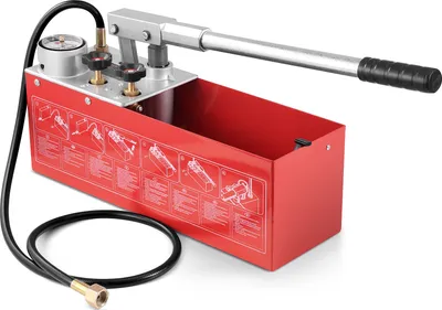 A red manual hydraulic pressure testing pump with a silver lever and black handle, connected to a black hose with a brass fitting. The pump has instructional diagrams printed on its side.