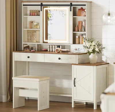 A vanity table with a mirror, stool, and cabinet in a room with white shiplap walls.