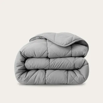 A folded gray comforter is shown against a light gray background.