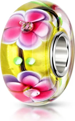 Gelber Glas Bead mit pinken Blüten und 3 Zirkonia Steinen im Glasinneren, schmale silberne Hülse, leicht schräg fotografiert auf weißem Hintergrund.