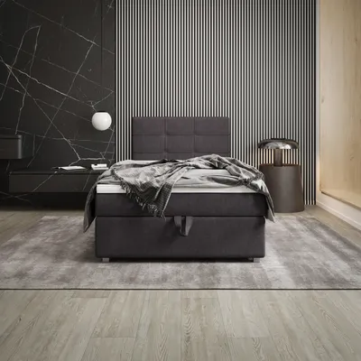 A modern bedroom with a boxspring bed, marble wall, and minimalist decor.