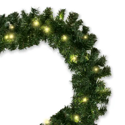 A close-up of a green artificial Christmas garland with warm white LED lights.