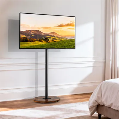 A TV stand with a TV displaying a landscape image, placed in a bedroom setting.