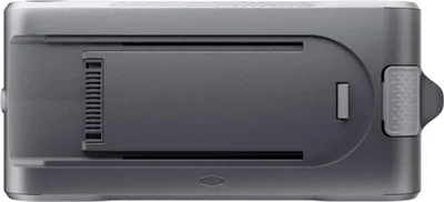 A close-up side view of a gray electronic device, possibly a battery pack or accessory for a vacuum cleaner, against a white background.