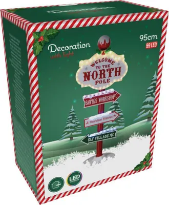 The image shows the packaging of a Christmas decoration, a lighted North Pole signpost with four directional planks.
