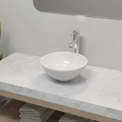 A white ceramic basin with a chrome faucet sits on a marble countertop.