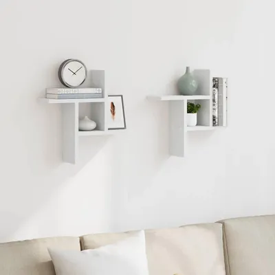 Two white wall shelves mounted on a white wall above a sofa.