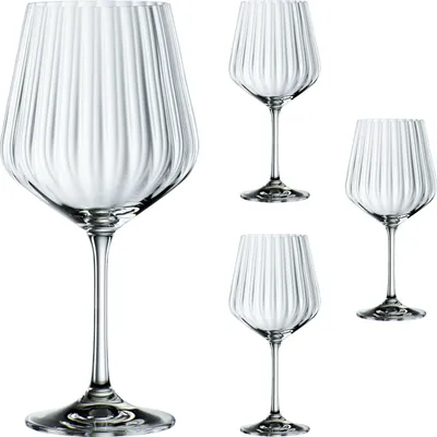 Four clear, fluted wine glasses are arranged on a white background.