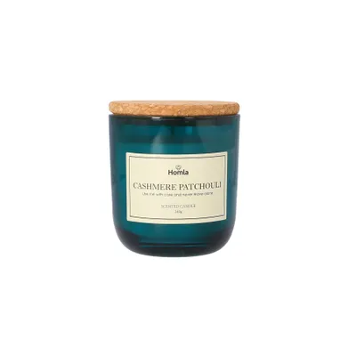 A teal glass candle with a wooden lid and a cream-colored label.
