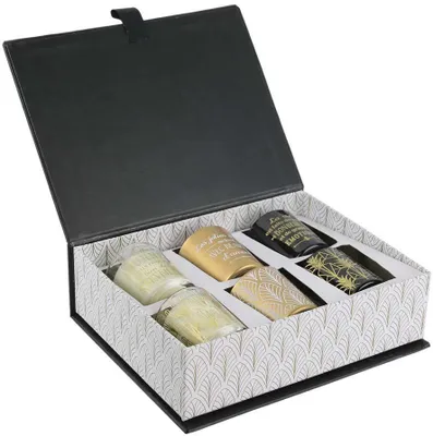 A gift box containing six scented candles, with a decorative pattern on the inside of the box and on some of the candles.