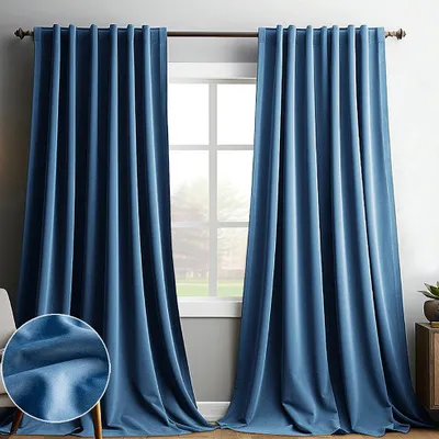 Two blue velvet curtains hanging in front of a window.