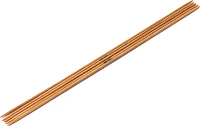 A set of wooden knitting needles laid diagonally on a white background.