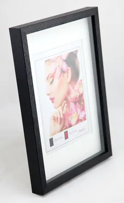 A black wooden picture frame with a white mat and a portrait of a woman with flowers.