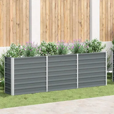 A raised garden bed in a garden setting, with plants growing in it.