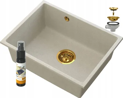 A beige sink with gold fixtures and a cleaning spray bottle.