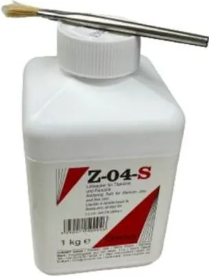 A white bottle of soldering flux with a brush resting on top.