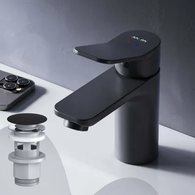 A black faucet and pop-up drain assembly are displayed on a white surface against a gray background.
