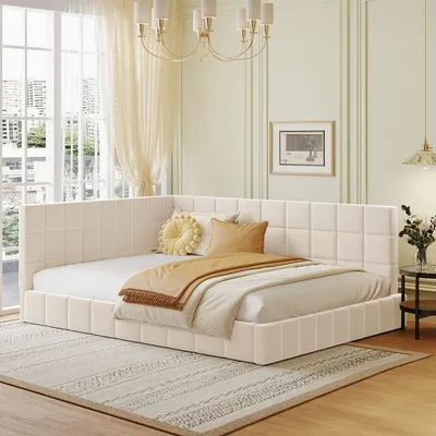 A bedroom scene with a beige daybed, pillows, and blankets.