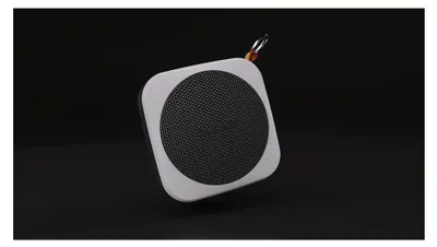 A square portable Bluetooth speaker with a circular mesh speaker grille is shown against a black background.