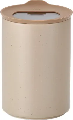 A close-up studio shot of a sand beige ceramic storage jar with a tan lid.