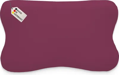 A purple pillow with a tag indicating it is made in Germany.