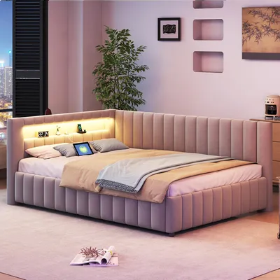 A modern bedroom with a L-shaped bed featuring integrated LED lighting and a tablet on the pillows.