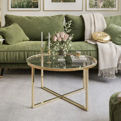 A living room scene with a green sofa and a round coffee table.