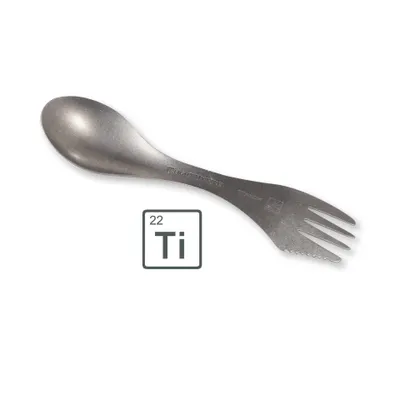 A titanium spork with a spoon on one end and a fork with a serrated edge on the other, placed on a white background next to a periodic table tile for Titanium.