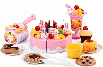 A collection of toy birthday cake and dessert items, including a pink cake, cupcakes, a milkshake, cookies, and a cutting toy.