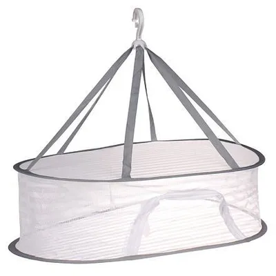 A white mesh drying net with gray trim and straps, suspended by a white hook.