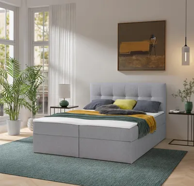 A bedroom scene with a bed, plants, and artwork.