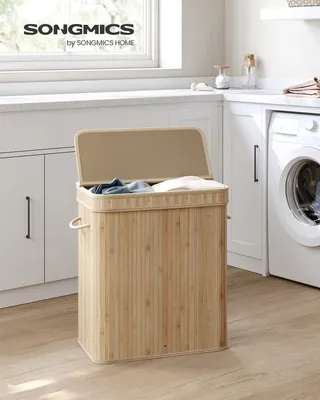 A laundry room with a washing machine and cabinets, featuring a bamboo laundry basket.