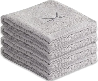 A stack of four grey guest towels with an embroidered design on the top towel.