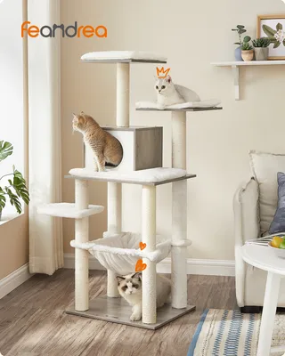 A multi-level cat tree with two cats, one wearing a crown, in a living room setting.
