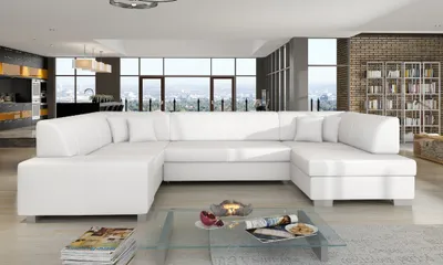 A large white sectional sofa in a modern living room with large windows overlooking a city.