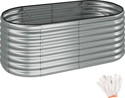 A silver, oval-shaped raised garden bed made of corrugated metal, shown from a slightly elevated side angle. A pair of white work gloves with orange trim is visible in the bottom right corner.