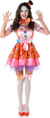 A woman dressed as a clown stands against a white background.