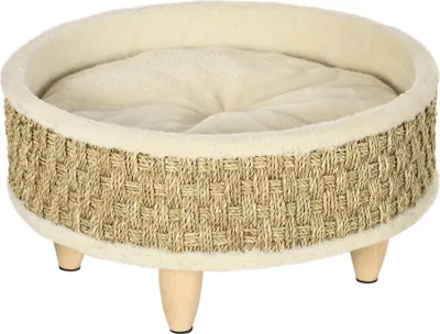 A round pet bed with a woven exterior and a plush interior, elevated on four wooden legs.