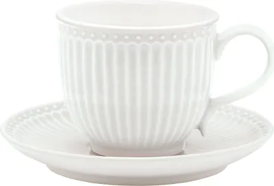 A white ceramic cup and saucer with a ribbed texture and a beaded rim.