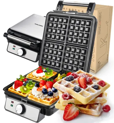 A waffle maker and waffles are displayed against a white background. The waffle maker is open, revealing the waffle grid. Several waffles, topped with fruit and whipped cream, are arranged in the foreground.