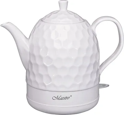 A white electric kettle with a textured surface sits on a white base.
